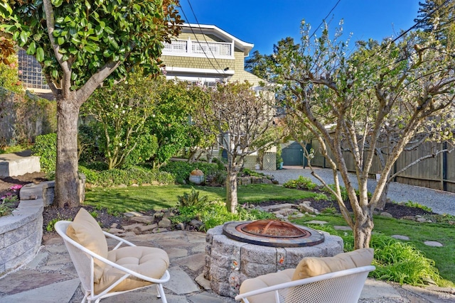 view of patio / terrace featuring a fire pit, a balcony, and fence