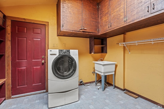 laundry area featuring baseboards, cabinet space, washer / clothes dryer, and light floors