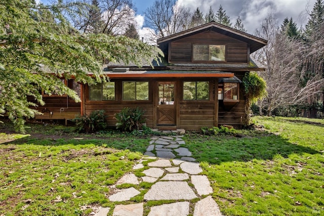 chalet / cabin with a front lawn