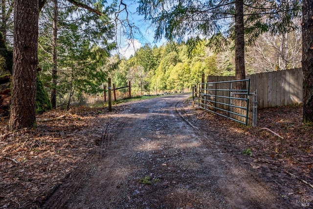 view of gate with fence and a view of trees