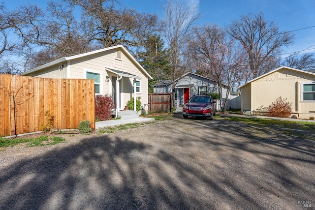 view of side of home featuring an outbuilding and fence