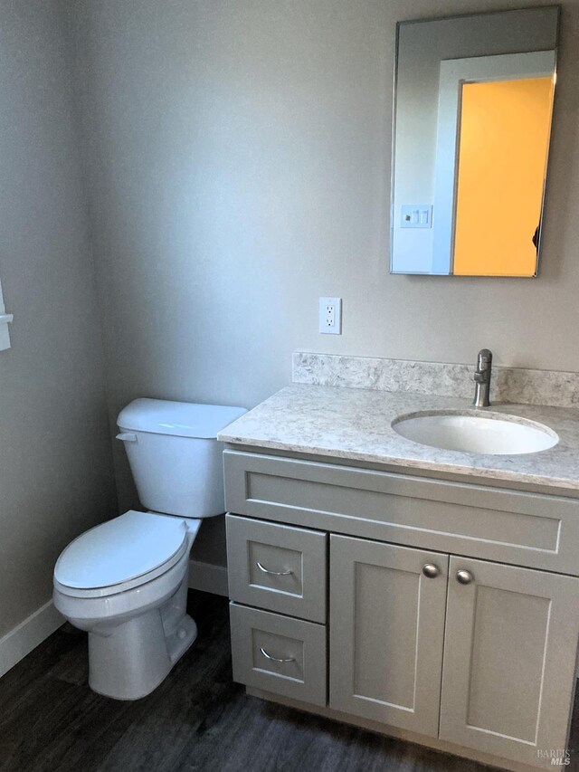 680 N State St, Ukiah, CA 95482 - half bathroom with baseboards, toilet, wood finished floors, and vanity