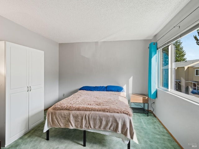 bedroom featuring a textured ceiling, baseboards, and light carpet