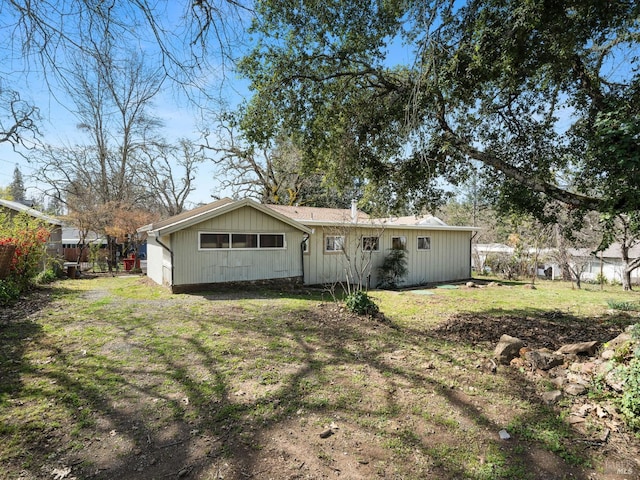 rear view of house featuring a yard and fence