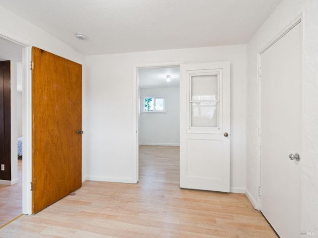 unfurnished bedroom featuring light wood-style flooring and baseboards