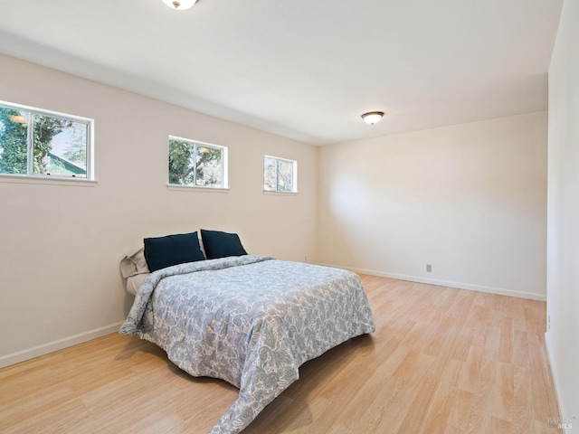 bedroom with baseboards and wood finished floors