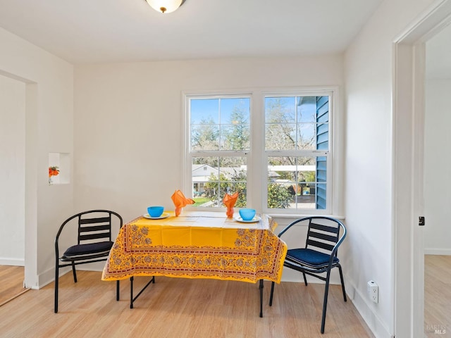 dining area with baseboards and wood finished floors