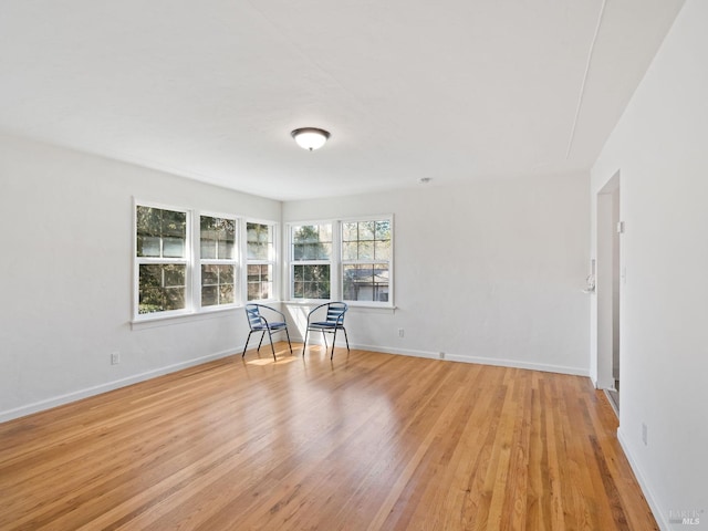 unfurnished room featuring baseboards and light wood-type flooring