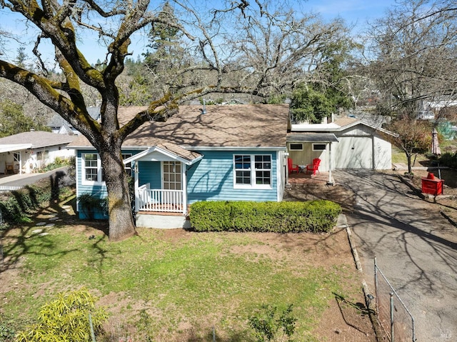 view of front of house featuring driveway, a porch, a front yard, and a shingled roof