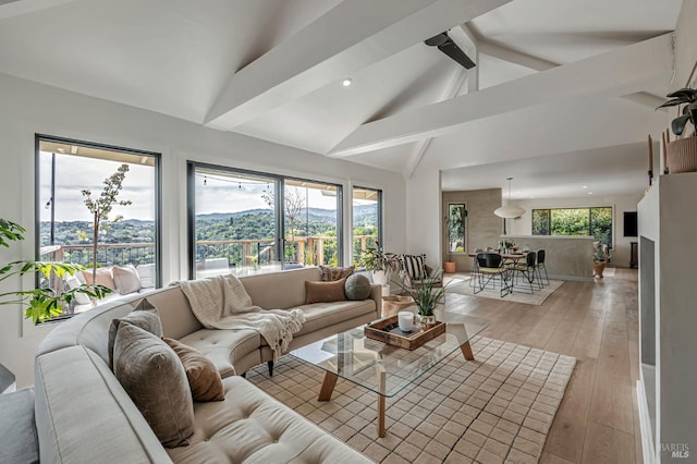 living room featuring plenty of natural light, beamed ceiling, high vaulted ceiling, and light wood-type flooring