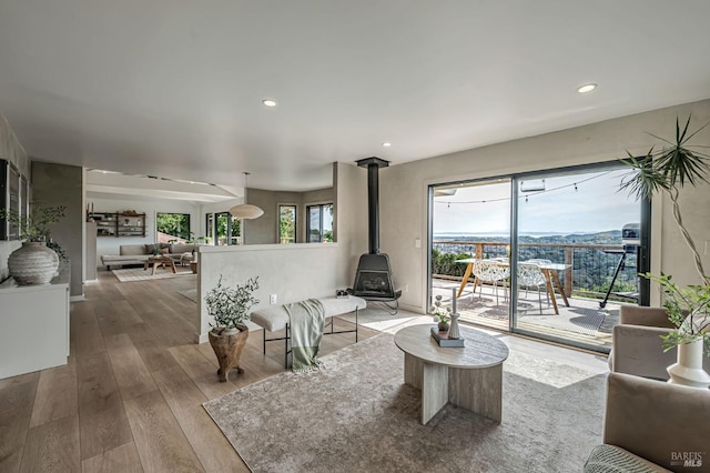 living area with recessed lighting, a wood stove, and hardwood / wood-style flooring