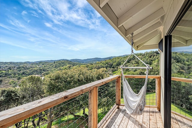 balcony featuring a mountain view and a wooded view