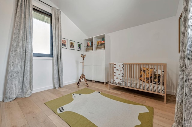 bedroom featuring vaulted ceiling, wood finished floors, and baseboards