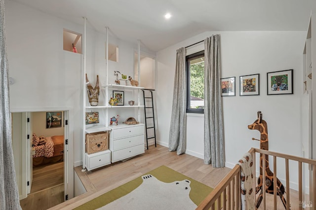 bedroom featuring baseboards, vaulted ceiling, and light wood finished floors