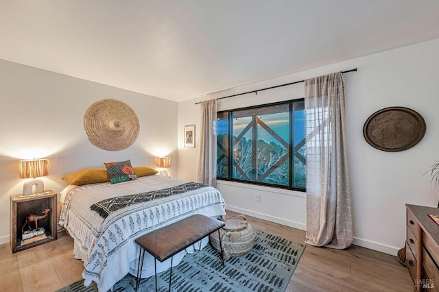 bedroom with light wood-style floors and baseboards