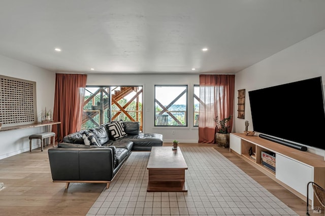 living room featuring light wood finished floors, recessed lighting, and a healthy amount of sunlight