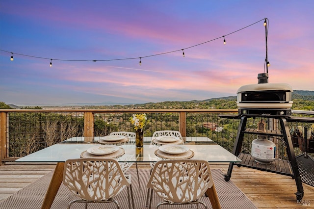 wooden deck featuring a mountain view and outdoor dining space