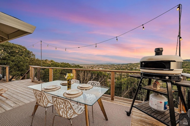 deck featuring outdoor dining space and a grill