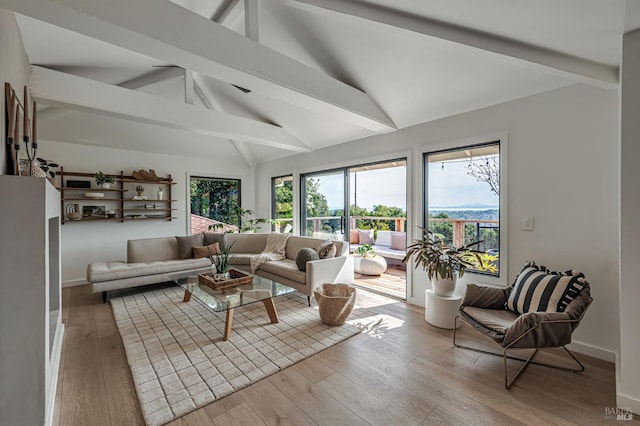 living area with ceiling fan, baseboards, light wood-style flooring, and vaulted ceiling with beams