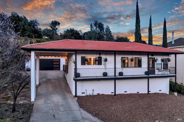 view of front of house featuring driveway, stucco siding, a garage, crawl space, and a tiled roof