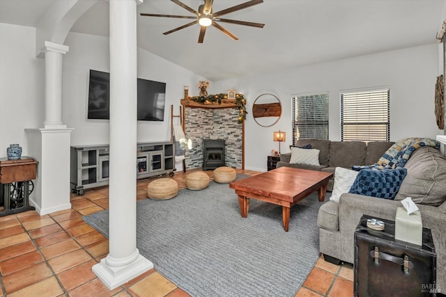 living room featuring vaulted ceiling, a wood stove, a ceiling fan, and decorative columns