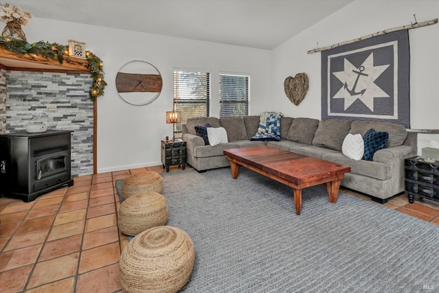 living area featuring light tile patterned floors, baseboards, lofted ceiling, and a wood stove