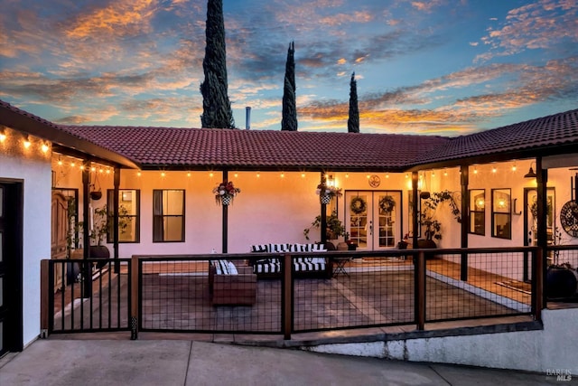 view of front of house featuring french doors, stucco siding, and a tile roof