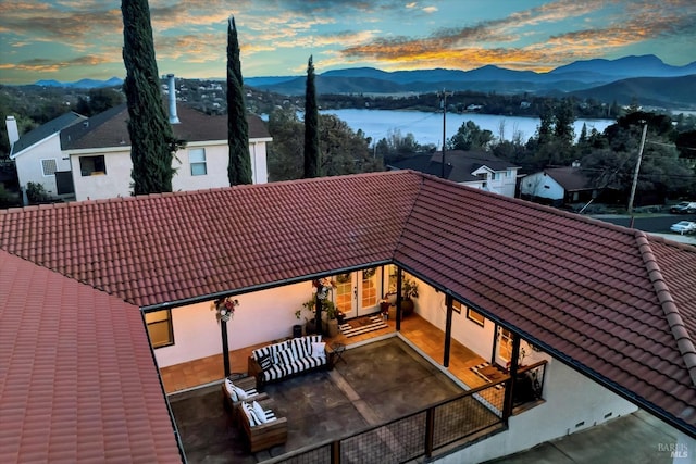 rear view of property with a patio area, a mountain view, and a tile roof