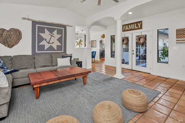 tiled living room featuring a ceiling fan, baseboards, lofted ceiling, decorative columns, and french doors