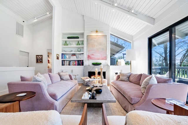 living room featuring built in features, a high end fireplace, track lighting, wooden ceiling, and beamed ceiling