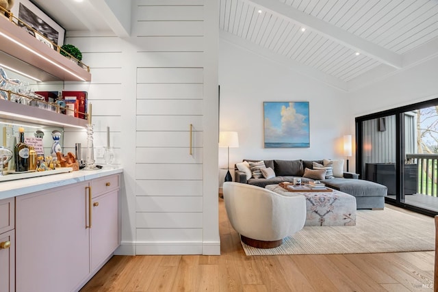 living room with high vaulted ceiling, light wood-style flooring, recessed lighting, beamed ceiling, and a dry bar