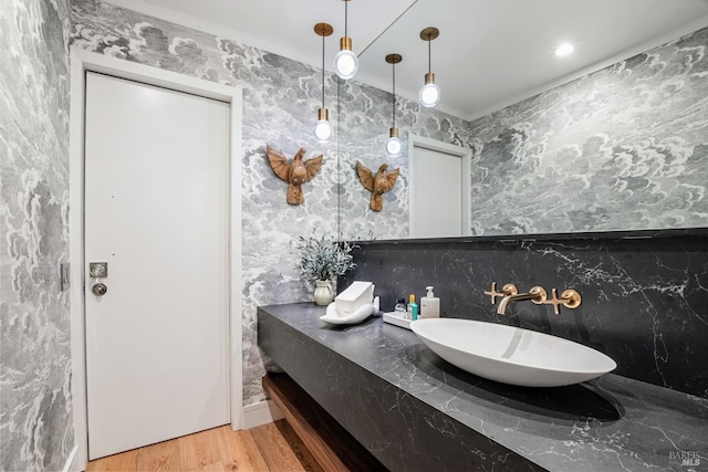 bathroom featuring ornamental molding, vanity, and wood finished floors