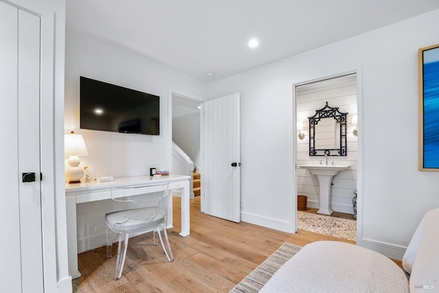 office space featuring a sink, baseboards, light wood-style floors, and recessed lighting