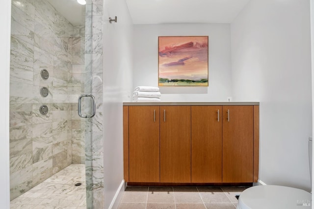 bathroom with a shower stall, toilet, and baseboards