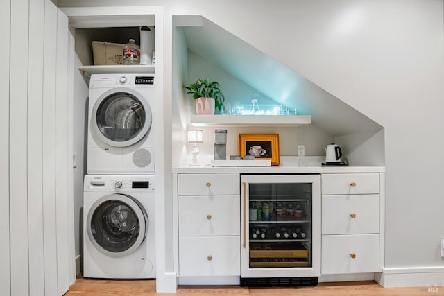 laundry room with stacked washing maching and dryer, laundry area, wine cooler, a dry bar, and light wood-type flooring