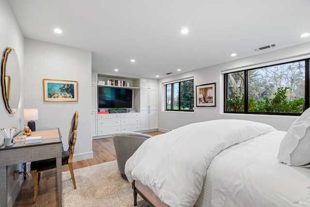 bedroom with light wood finished floors, visible vents, and recessed lighting