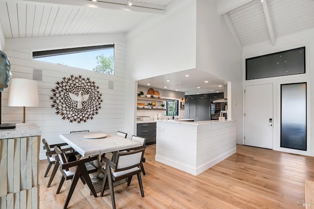 dining area featuring wooden ceiling, light wood-style flooring, beamed ceiling, and high vaulted ceiling