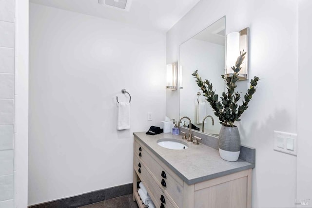 bathroom featuring visible vents, baseboards, and vanity