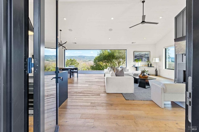 living area featuring a wealth of natural light, light wood-type flooring, a ceiling fan, and recessed lighting