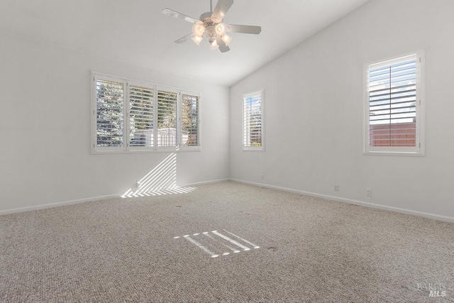 unfurnished room with vaulted ceiling, carpet flooring, baseboards, and ceiling fan