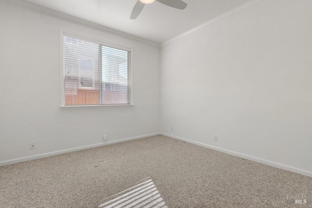 carpeted empty room with a ceiling fan, crown molding, and baseboards