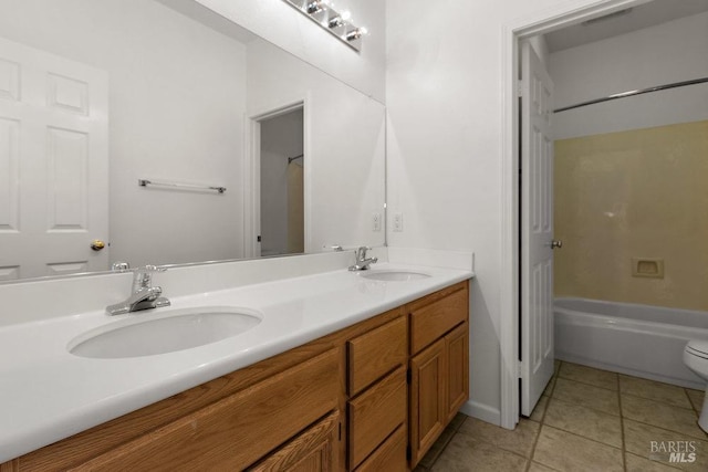 full bathroom with a sink, toilet, double vanity, and tile patterned floors