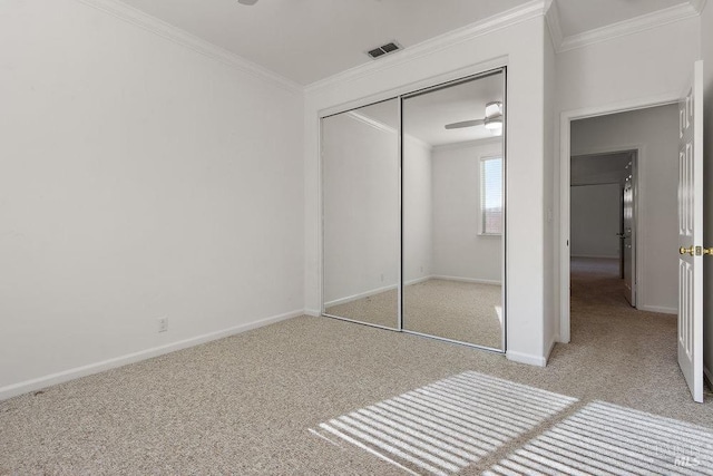 unfurnished bedroom featuring crown molding, carpet flooring, baseboards, and visible vents