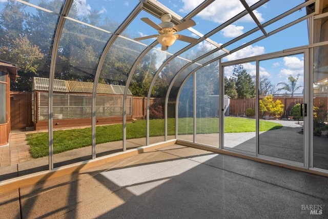 unfurnished sunroom with lofted ceiling and a ceiling fan