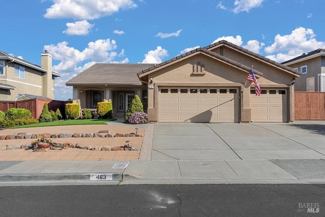 ranch-style house featuring stucco siding, driveway, a tile roof, fence, and a garage