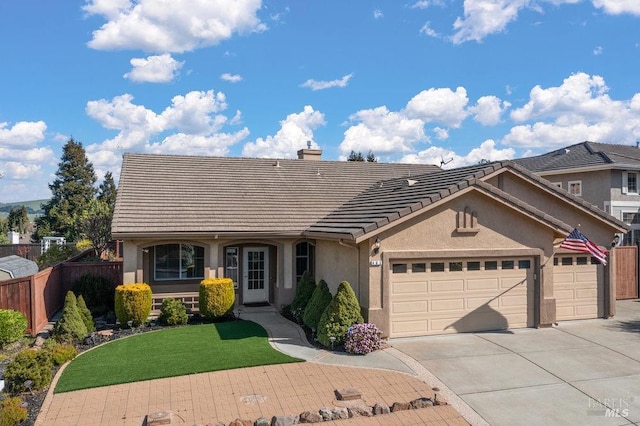 view of front of property with fence, driveway, an attached garage, stucco siding, and a tile roof