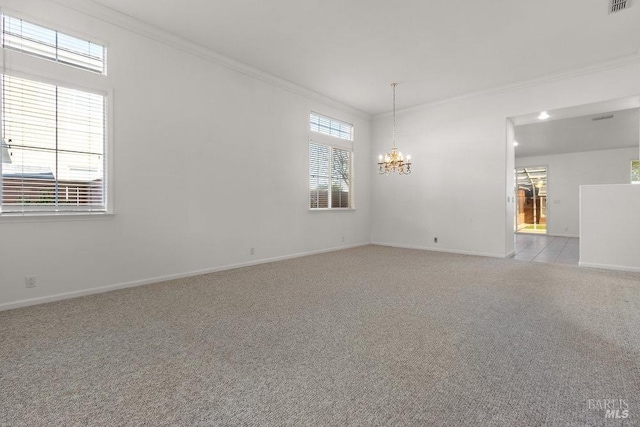 empty room with a notable chandelier, baseboards, carpet, and ornamental molding