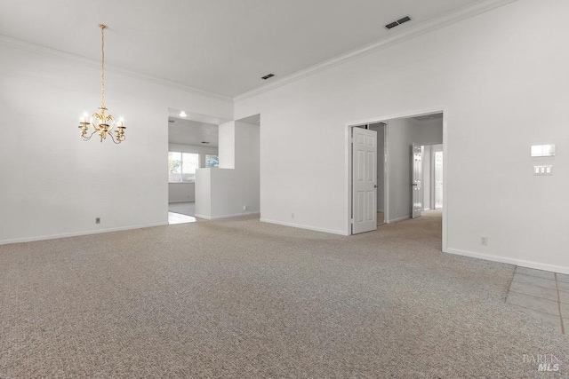 carpeted spare room featuring a notable chandelier, visible vents, baseboards, and ornamental molding