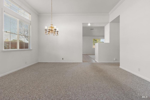 spare room featuring ornamental molding, light colored carpet, baseboards, and a chandelier