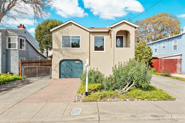 view of front of property with fence, a garage, driveway, and stucco siding